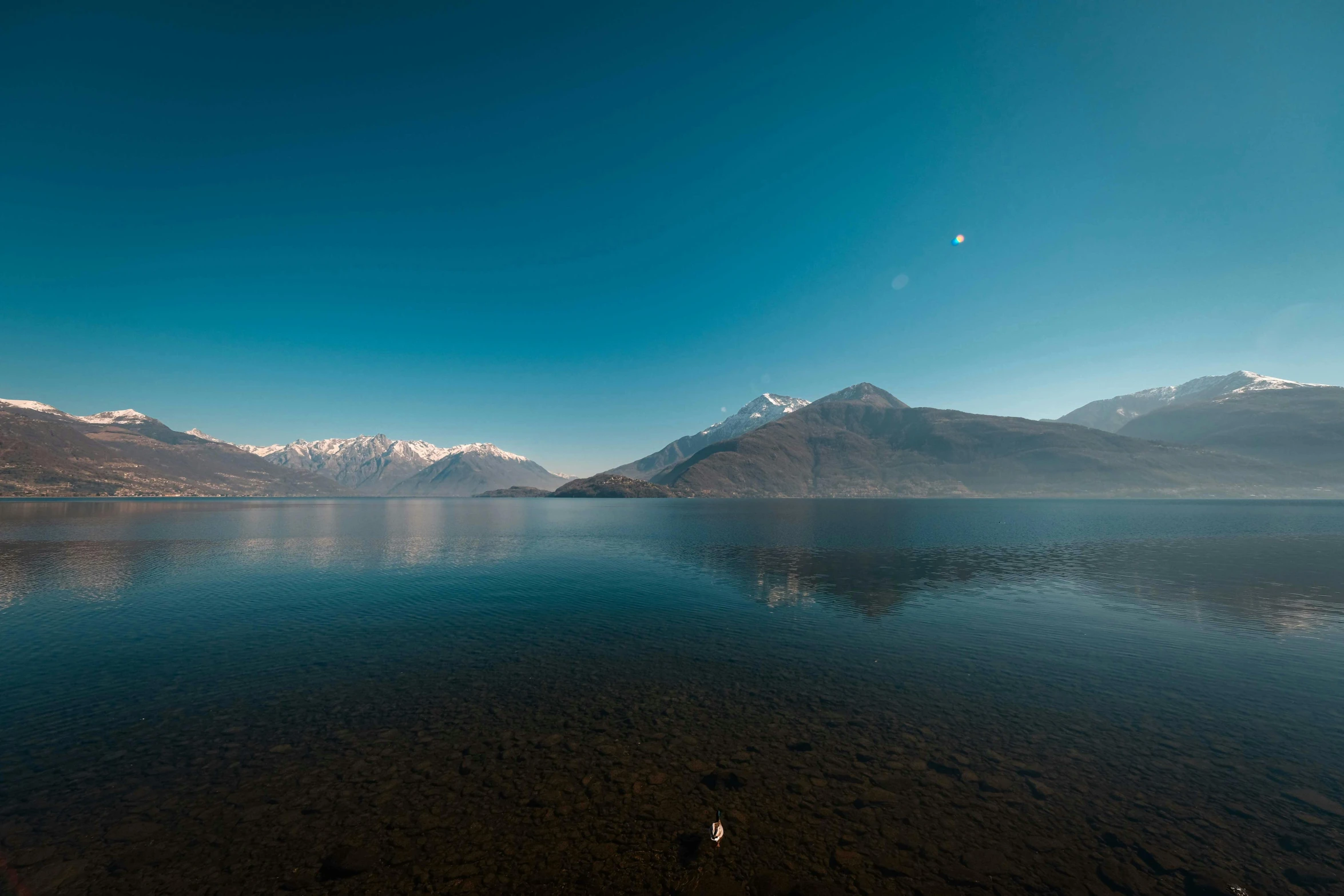 there is a clear body of water surrounded by mountains