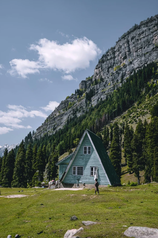 a large house is on a green mountain