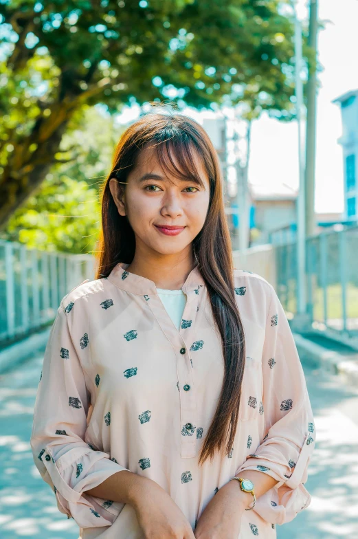 a beautiful young lady wearing a flowered shirt is standing on the sidewalk