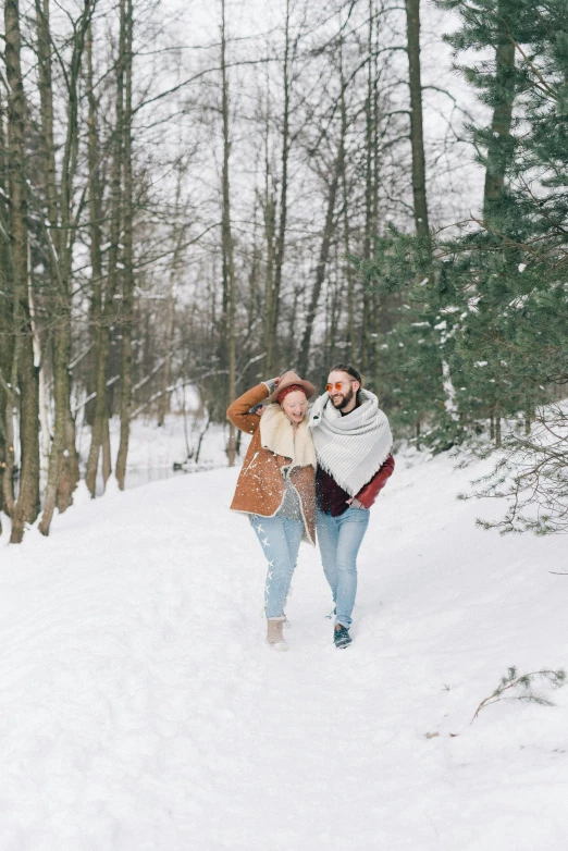 two people walking through the snow on a snowy day