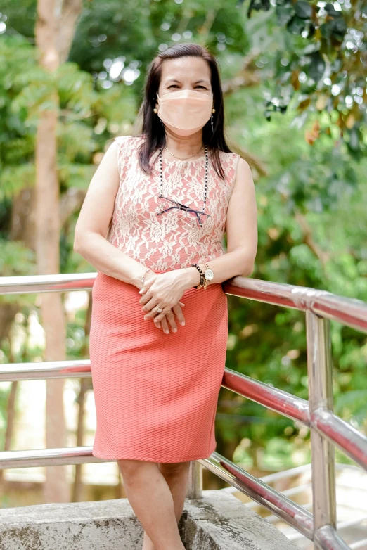 a woman is sitting on some stairs while wearing a mask