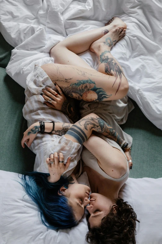 a man and woman laying on their backs in the bed