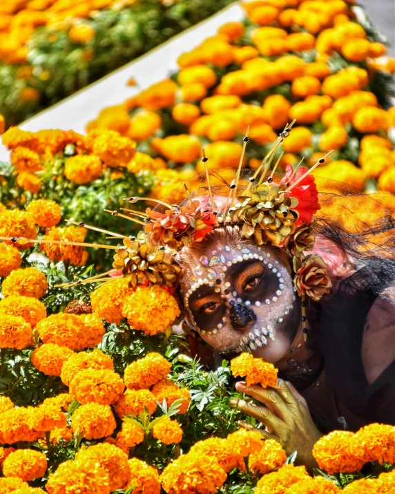 a person with painted face and nose covered in flowers