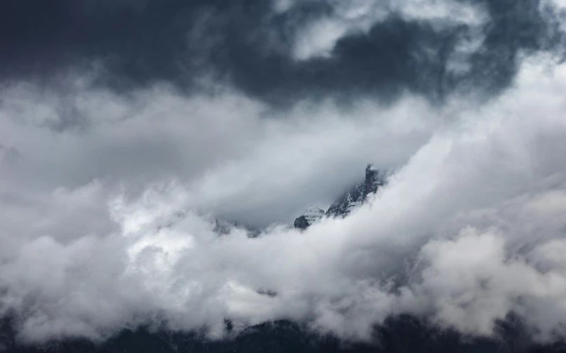 the clouds are moving through the landscape over mountains