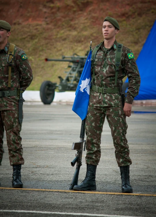 two soldiers standing near one another holding a flag