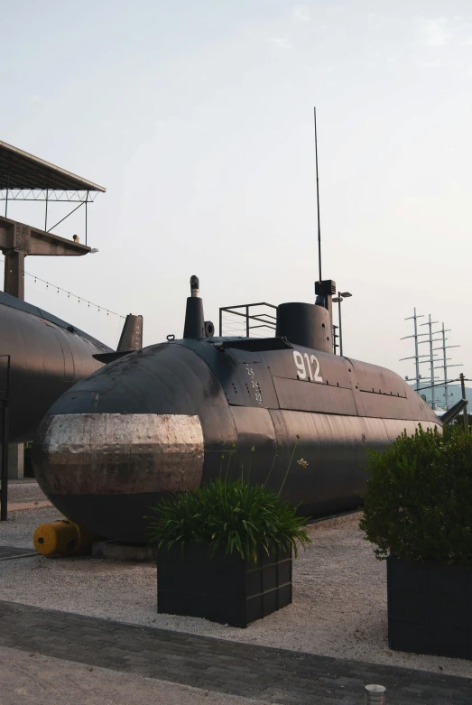 a submarine sitting on top of cement next to shrubbery