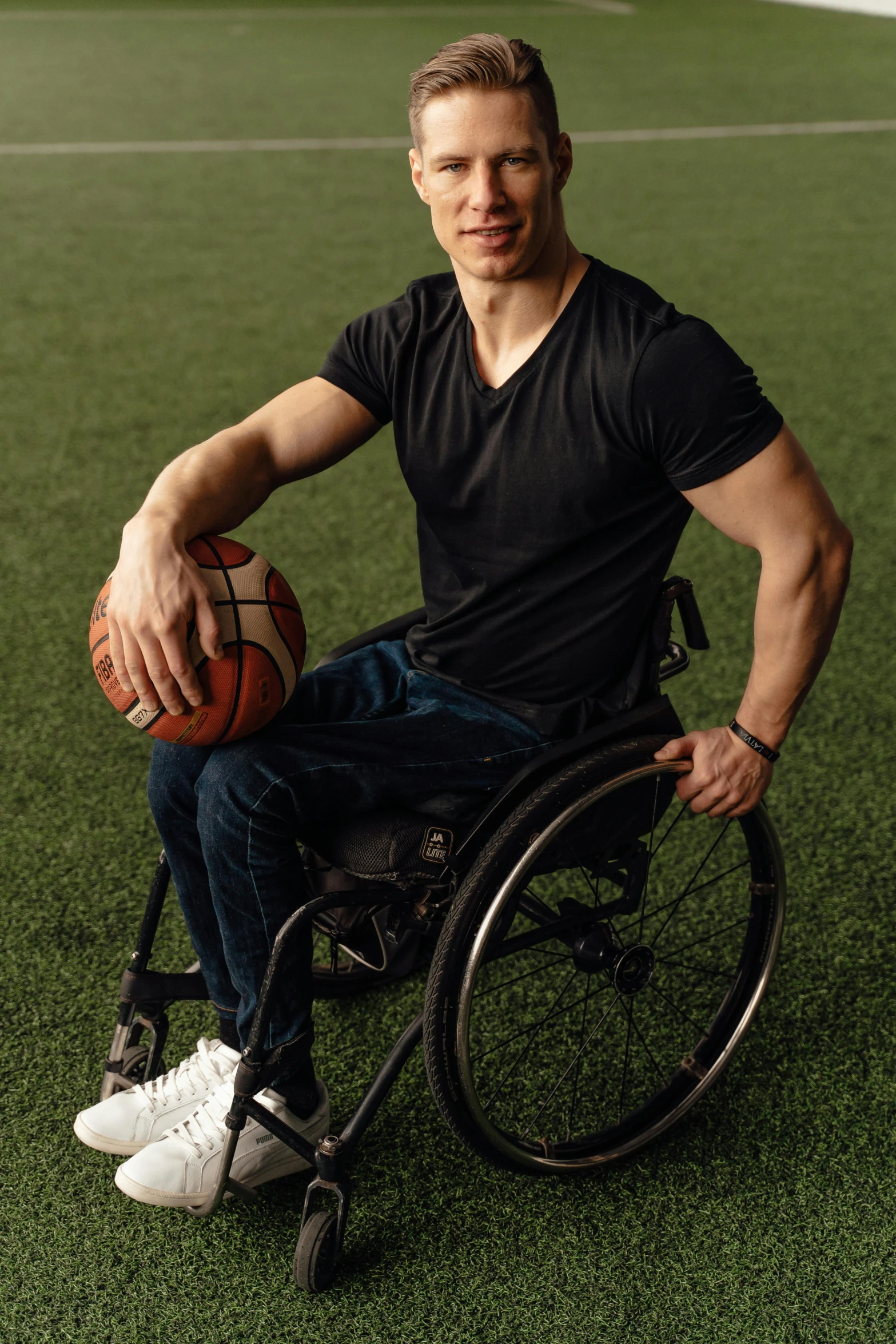 a young man in a wheelchair is holding onto a ball