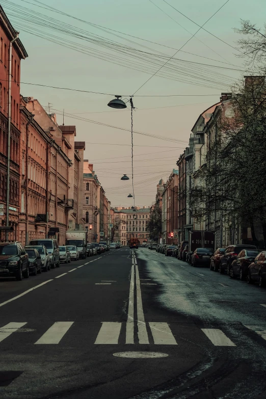 an empty street is shown with cars parked on the sidewalk