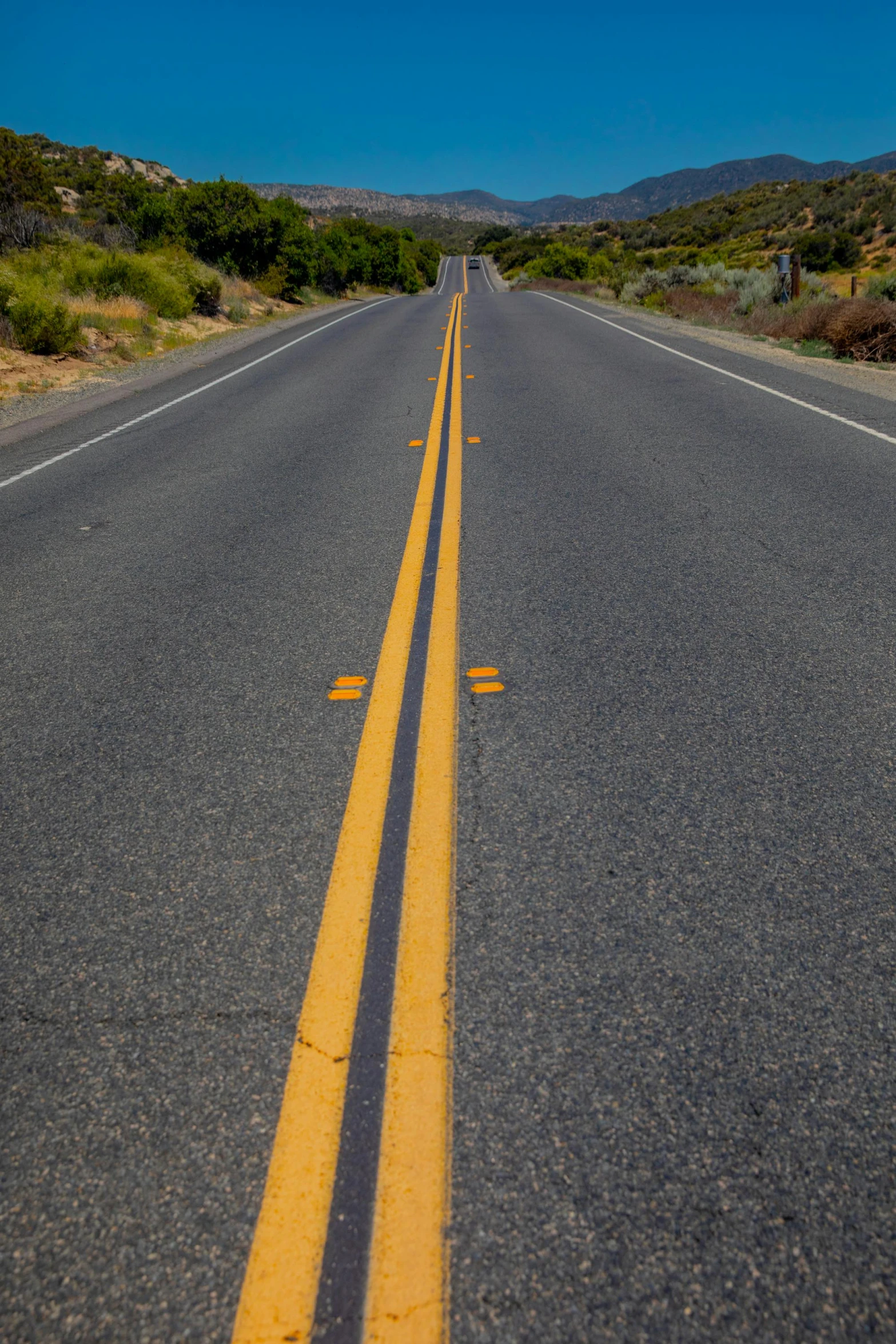 a lone road through the desert leading toward the mountains