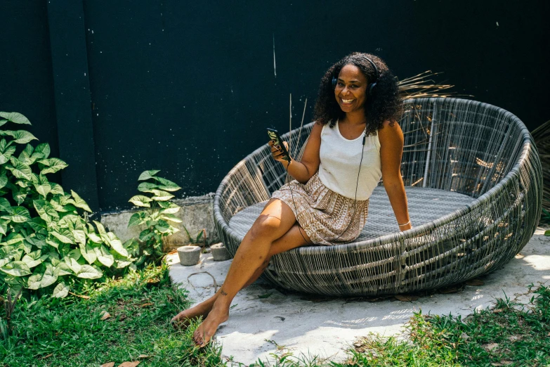 a young black woman sitting on a garden chair