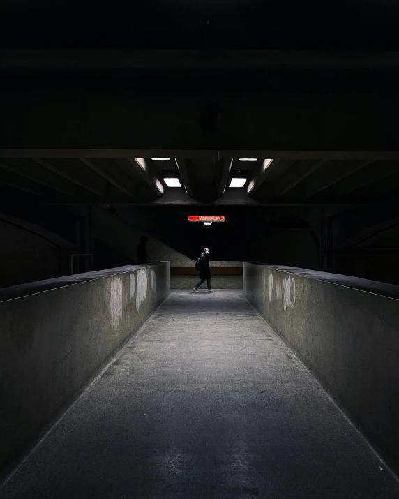 a skateboarder riding in a darkened area next to some buildings