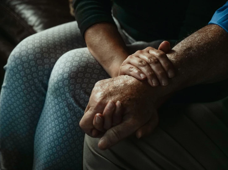 people sitting on couchs holding hands together