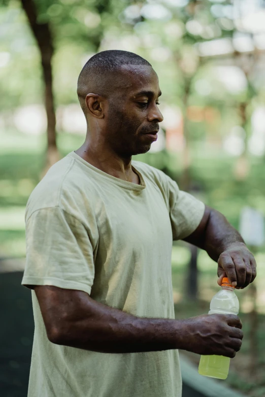 man holding onto an orange and white bottle