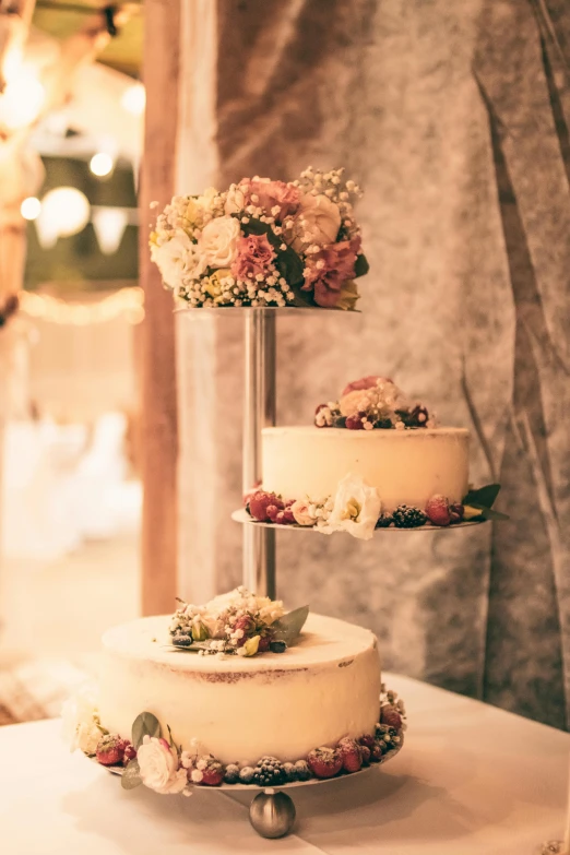 a tall three tiered cake sits on top of a table