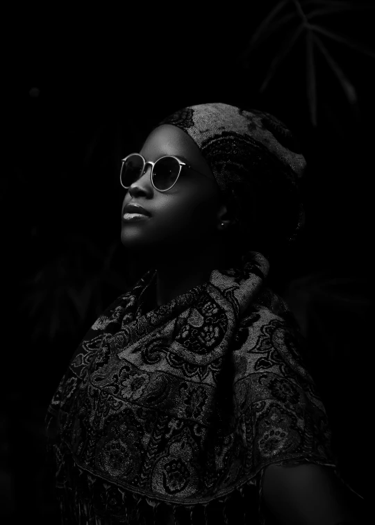 a beautiful woman wearing sun glasses and an ornate patterned head wrap