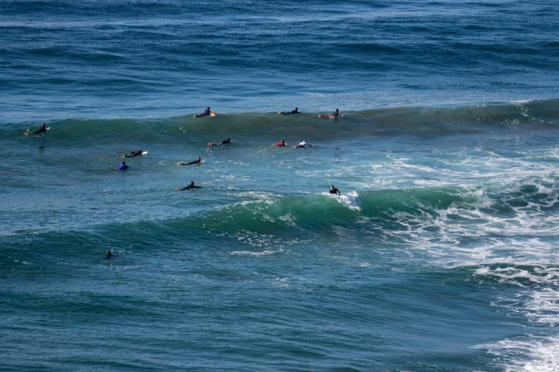 a group of people swimming in the ocean next to wave