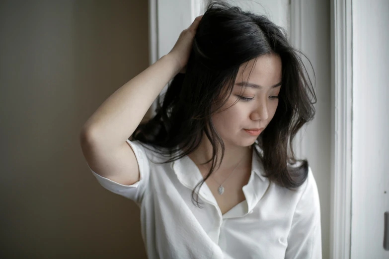 a woman holds her hair to her head