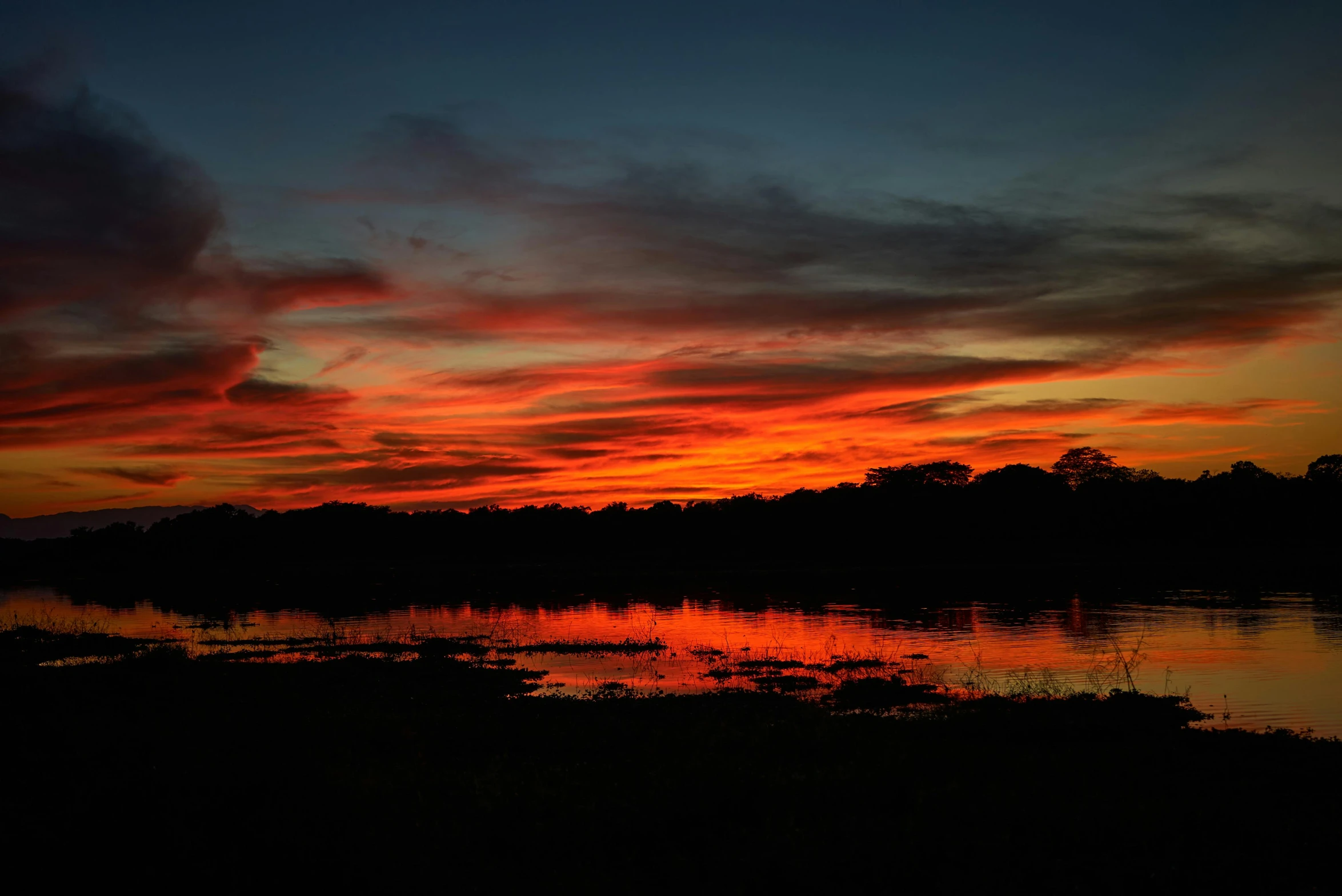 a sunset in the distance and reflecting on a body of water