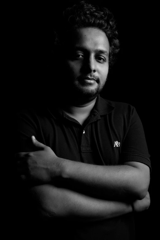 a young man with his arms crossed posing for a black and white po