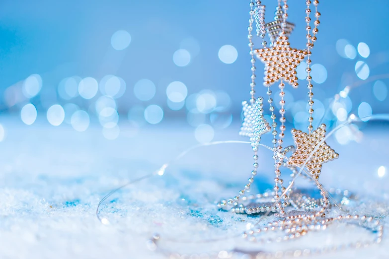 a necklace in the snow with crystal stars on it