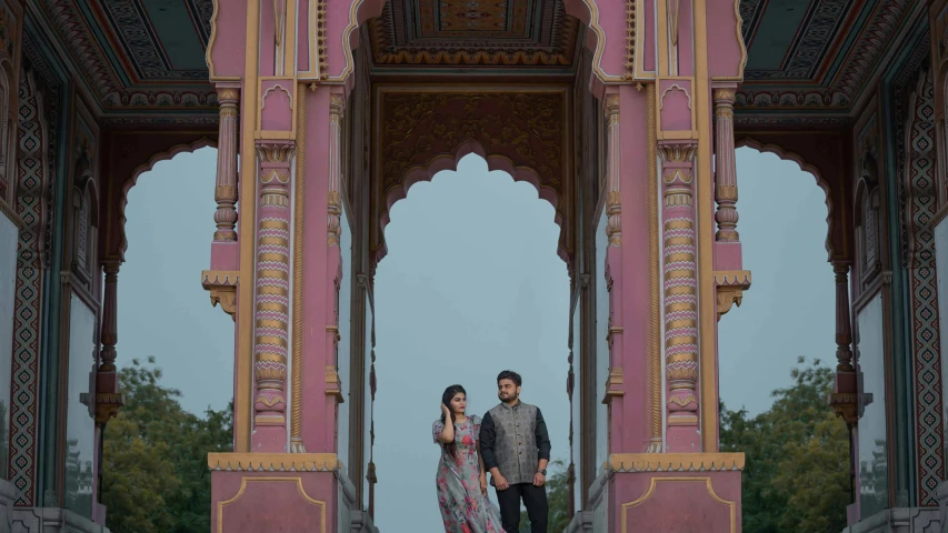 couple standing in front of a colorful archway