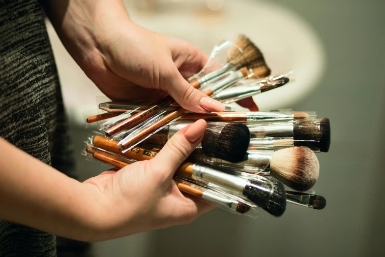 a person holding several brushes in their hands