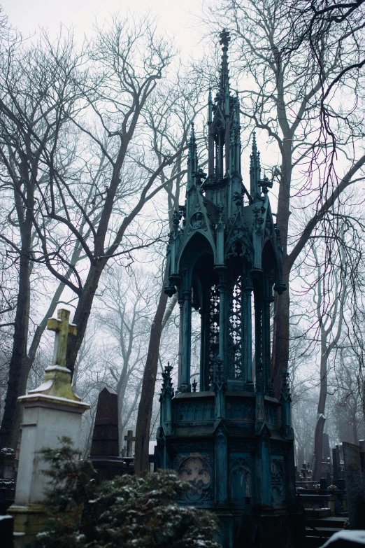 a clock on top of an ornate tower in a graveyard