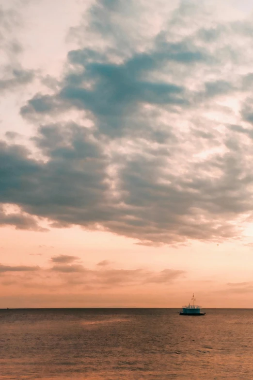 a fishing boat sailing the open ocean on a cloudy day