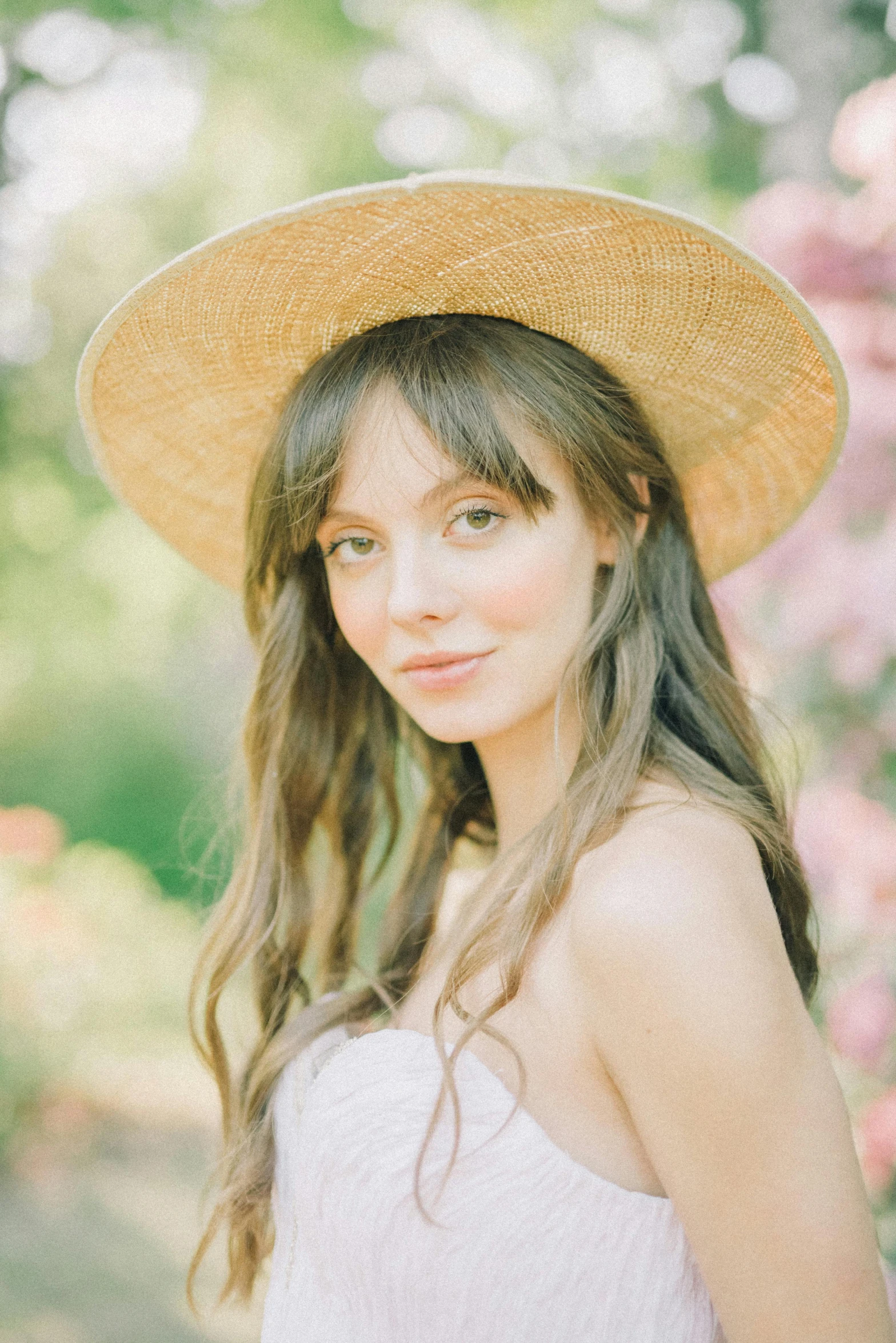 a beautiful woman with long hair wearing a straw hat