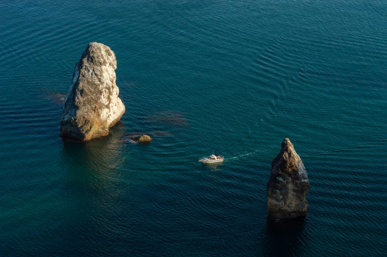 a large body of water with some rocks and a boat