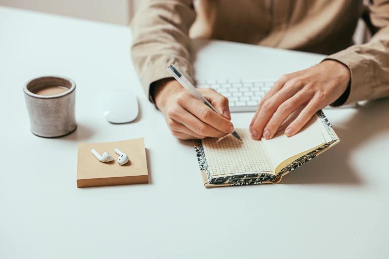 man using a book with a pen and paper