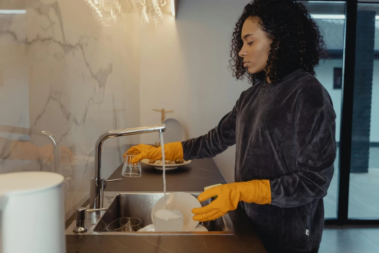 a woman washing her hands on a sink