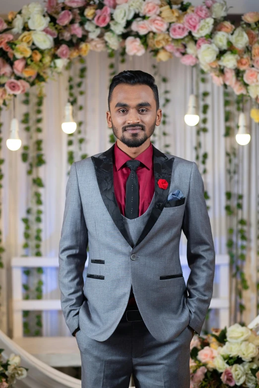 a man dressed in a grey suit poses for a picture