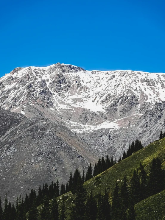 some tall mountains covered in snow against a blue sky