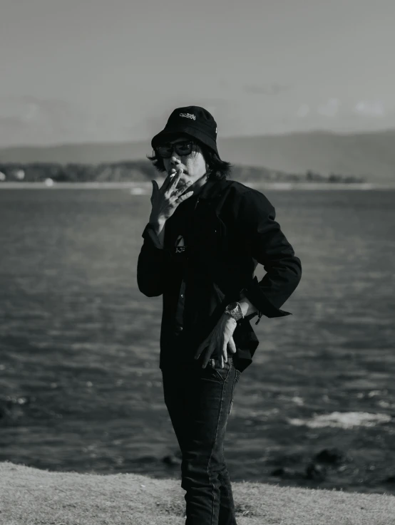 an image of a person smoking by the water