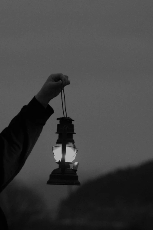 a black and white po of a person holding a lantern