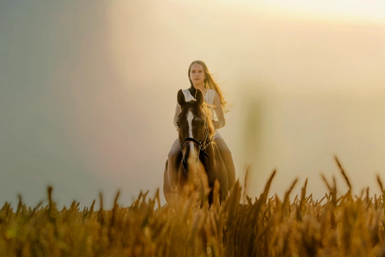 a woman in an overcoat riding a horse through a field