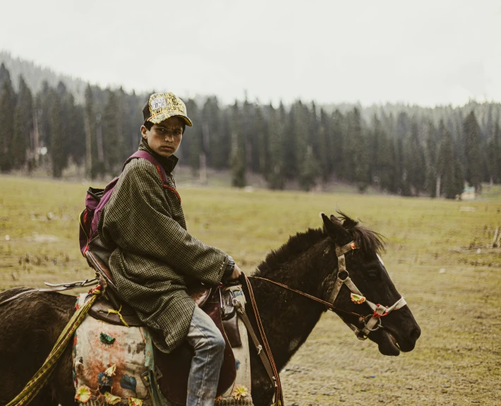 a man with a hat is riding on top of a horse