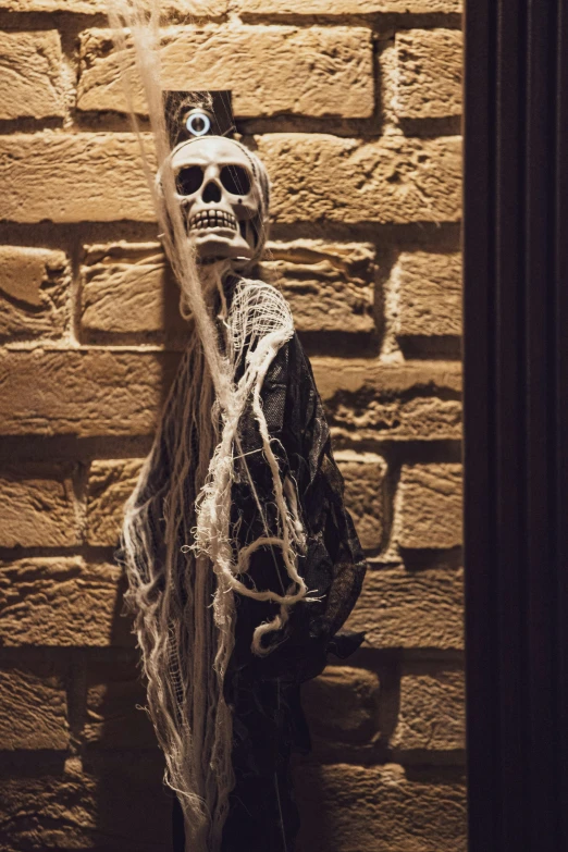 a skeleton statue in a corner of a brick wall