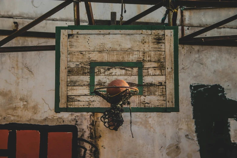 an old basketball hoop on the wall of an abandoned home