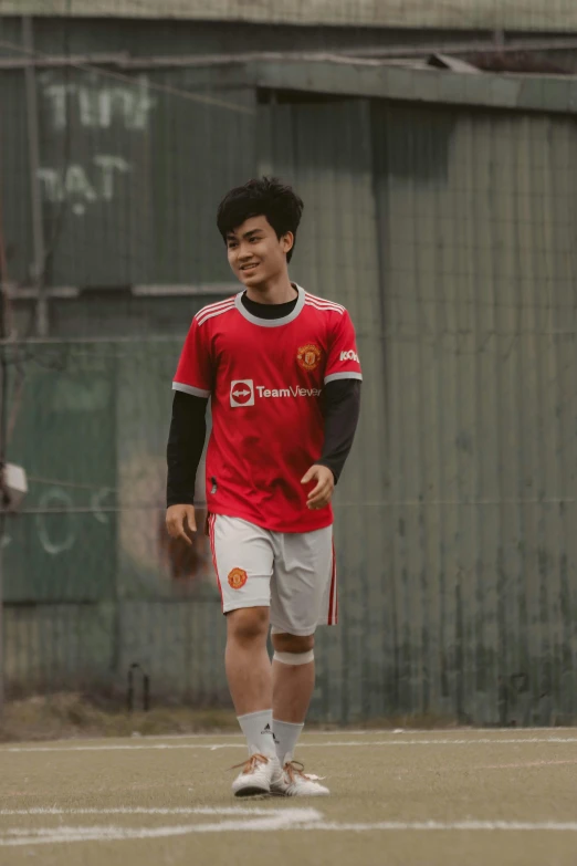 a boy stands on an outdoor soccer field