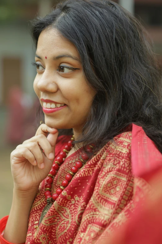 a woman in a red sari smiles as she poses for a po