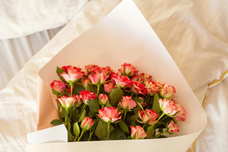 an arrangement of flowers is in the white paper