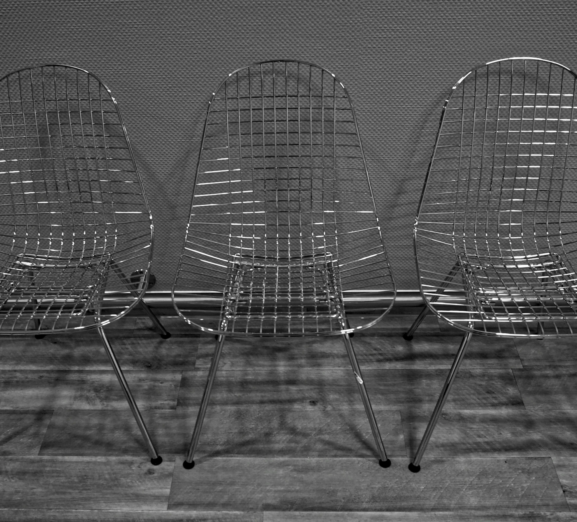 three chairs on wheels are sitting in front of a screen