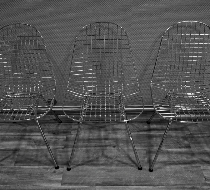 three chairs on wheels are sitting in front of a screen