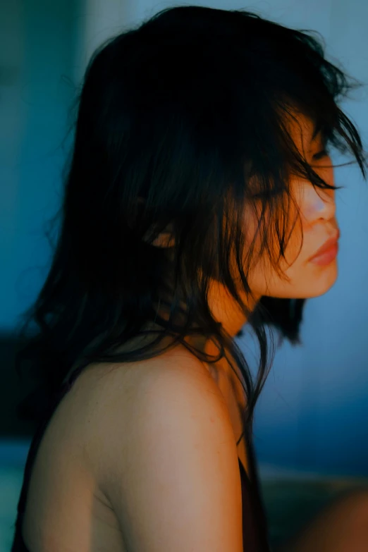 a woman in black top sitting on a bed