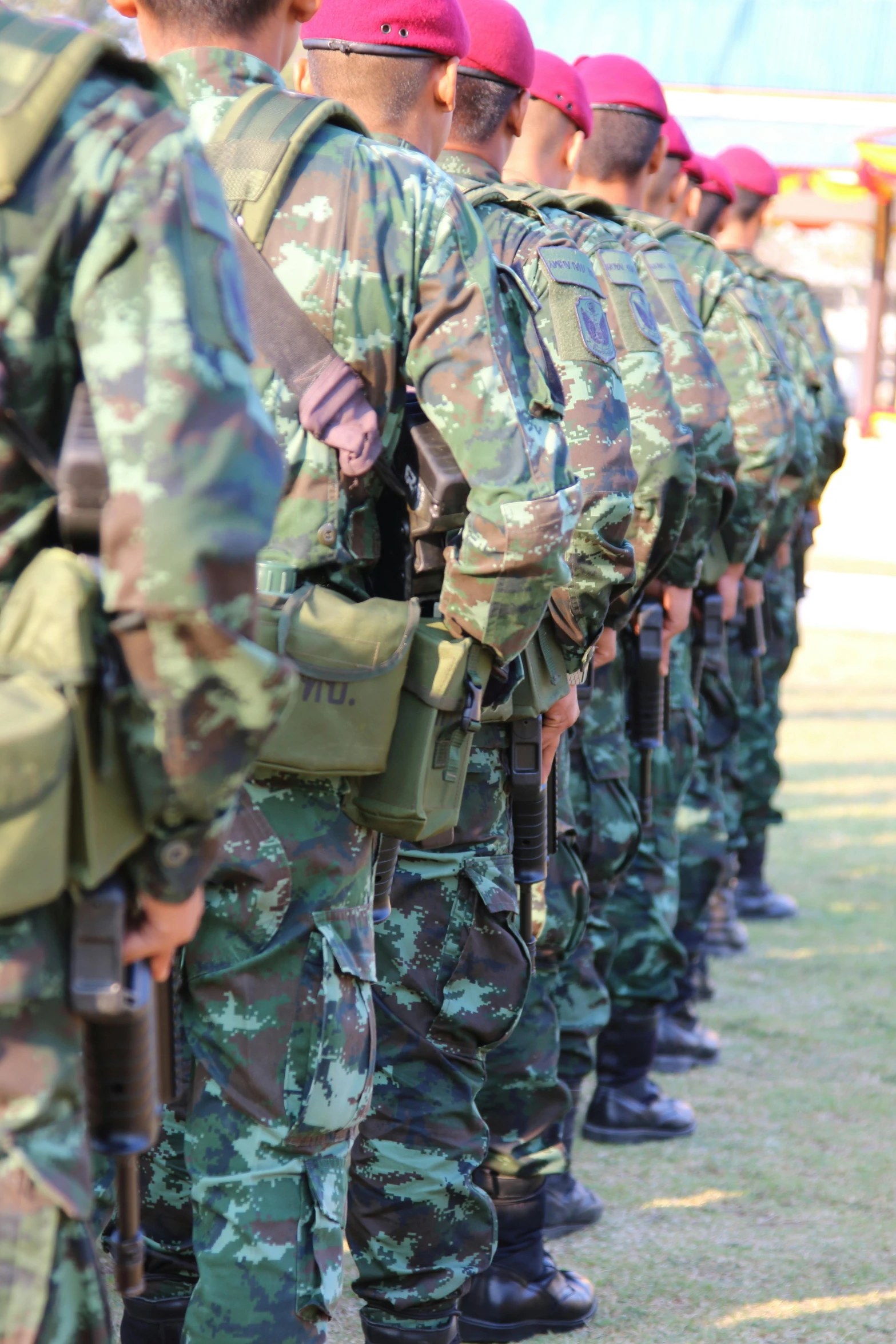 military men lined up together, wearing uniform and red caps