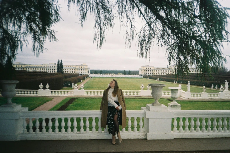 a woman posing for a picture next to a white railing