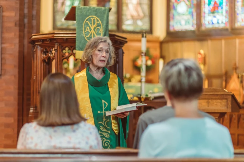 a woman standing at a table in front of a pew