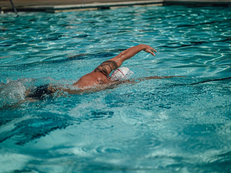 a person in a pool throwing a frisbee